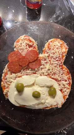 a mickey mouse pizza with olives and cheese