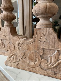 a close up of a wooden carving on a counter top with a mirror in the background