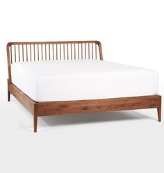 the bed frame is made from wood and has white sheets