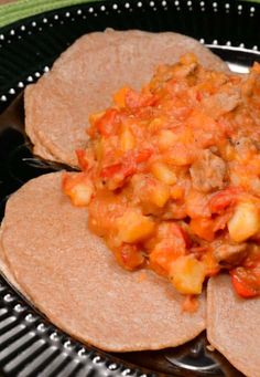 three tortillas on a plate with salsa and meat in the middle, ready to be eaten