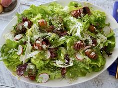 a white plate topped with lettuce and radishes