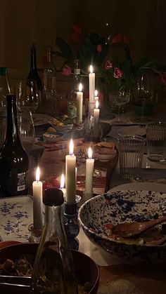 a dinner table with candles and dishes on it