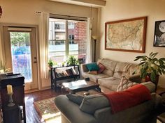 a living room filled with furniture and a fire place in front of a map on the wall