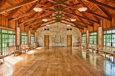 the inside of a large building with wooden floors and windows on both sides of it