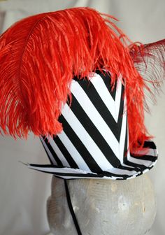 This extravagant vintage circus inspired ladies top hat is covered with a playful black and white striped cotton fabric and it is lusciously adorned with red and burgundy ostrich feathers.It is further trimmed with black ribbon and bow and a variety of buttons and clear crystals. Measurements : height 6.5 inches( 16 cm ) front to back 9 inches ( 23 cm ) side to side 8 inches ( 20 cm ) Need this but with feathers in another color? Just send me a message to talk about your options! THIS IS NOT A F High Crown Top Hat For Carnival, Circus Top Hat, Circus Hat, Top Hat Centerpieces, Steampunk Circus, Circus Ringmaster, Retro Circus, Ringmaster Costume, Women Steampunk