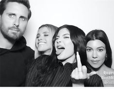 three women and one man posing for the camera with their fingers up in front of them