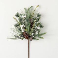 a pine cone with white flowers and greenery hanging from a wall mounted coat rack