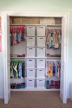 an organized closet with baskets and clothes