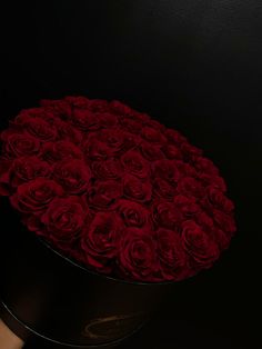 a round black box filled with red roses