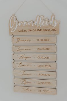 a wooden sign that says grandkids hanging on a wall with the names and dates