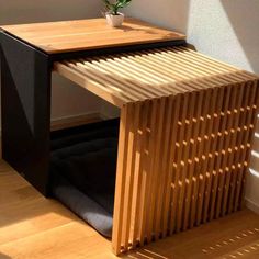 a wooden table with a plant on top of it next to a wall and floor