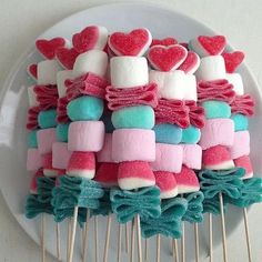 marshmallows are arranged on top of toothpicks with bows and hearts