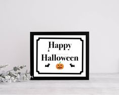 a black and white halloween card with the words happy halloween written on it next to some flowers