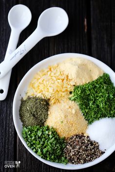 an assortment of spices in a bowl with measuring spoons