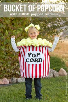 a little boy in a striped popcorn bag costume with the words bucket of popcorn written on it