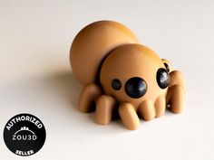 an orange toy with black eyes laying on a white surface