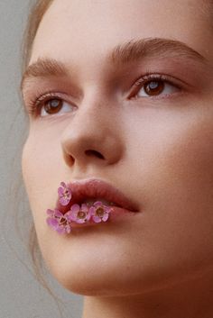 two pictures of a woman with pink flowers on her nose and the other side of her face