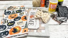 an assortment of crafting supplies sitting on top of a white wooden table with pumpkins