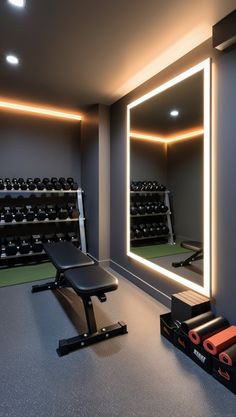 an exercise room with mirrors and treadmills in the foreground, lights on