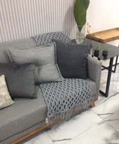 a gray couch with many pillows on it