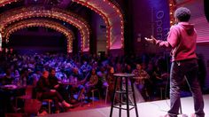 a man standing on top of a stage in front of an audience