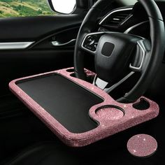 the interior of a car with a pink and black steering wheel cover on top of it