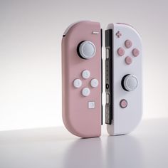 two nintendo wii game controllers sitting side by side on top of a white countertop