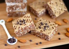 several pieces of cake sitting on top of a wooden cutting board next to almonds