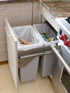 a kitchen with an open trash can next to the stove