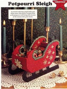 an old fashioned christmas sleigh with candles and decorations on the table in front of it