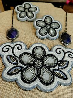 three pieces of beaded jewelry sitting on top of a table