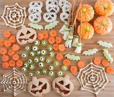 halloween treats are laid out on a cutting board with pumpkins and spider webs