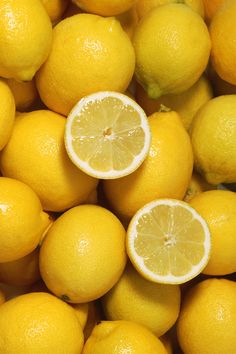 a pile of lemons with one cut in half