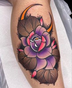 a woman's leg with a flower and crescent tattoo design on the calf area