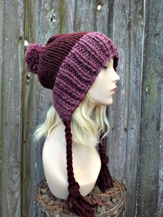 "Style: Slightly slouchy, split brim hat with long braided ties and a large pom pom on top. Color: This sample hat is shown in Fig purple and Claret, a burgundy red wine. Sizes: One size fits average teen or adult head size of 20\" to 23\" (50.5 cm to 58 cm). Fiber Content: 80% acrylic, 20% Wool Characteristics: Chunky, very soft, warm and cozy. Care Instructions: Hand wash, dry flat. Every item from Pixiebell is handmade and knit or crocheted to order, unless otherwise stated in title of the it Pixie Hat, Handmade Knitwear, Womens Hat, Warm Winter Hats, Ear Hats, Slouchy Hat