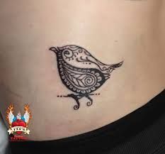 a woman's stomach with a bird tattoo on it