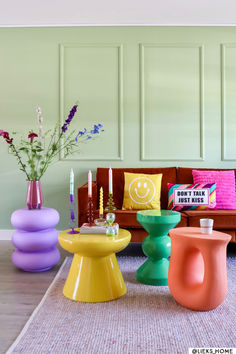 a living room filled with colorful furniture and flowers in vases on the coffee table