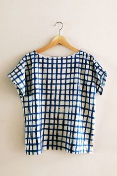 a blue and white checkered shirt hanging on a wall