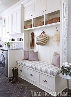 a laundry room filled with lots of white cabinets