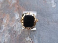 Art Deco Filigree Black Onyx Ring 14k Ring.  This lady is gorgeous with a very sleek rectangle shaped onyx and beautiful two tone orange blossom type flowers along each side.  She weighs 3.4g and is a size 6, easily sizable by your local jeweler.  The stone measures 11.5 x 10mm and the setting is 17mm tall.   All items are in previously loved, used condition so please review all photos closely and let me know if you have any questions prior to purchasing. I'm not a jeweler or gemologist & I pass Hallmarked Black Rectangular Rings, Formal Black Jewelry With Rectangular Shape, Rectangular Black Hallmarked Ring, Black Rectangular Jewelry For Formal Occasions, Rectangular Onyx Ring For Formal Occasions, Formal Black Jewelry With Rectangular Stone, Formal Rectangular Onyx Ring, Ring Black Stone, Onyx Signet Ring