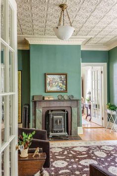 a living room with green walls and a fireplace