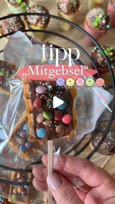 a hand holding a popsicle with chocolate and sprinkles on it that says tip mittgebsel