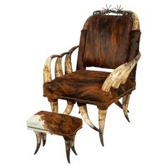 an old chair and foot stool made out of cow hides with horns on them