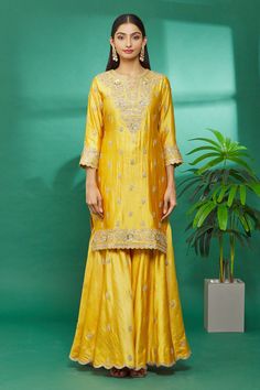 Yellow kurta with floral hand embroidery. Paired with embroidered sharara and organza dupatta.
Component: 3
Pattern: Embroidered
Type Of Work: Floral
Neckline: Round
Sleeve Type: Three Quarter
Fabric: Kurta and Sharara: Pure spun silk, Dupatta: Organza
Color: Yellow
Other Details: 
Floral hand embroidery
Organza dupatta
Occasion: Wedding - Aza Fashions Designer Raw Silk Sets With Dori Work, Semi-stitched Slub Silk Sets With Dori Work, Designer Festive Sharara With Gota Work, Designer Wear Sharara With Gota Work For Festive Season, Embroidered Raw Silk Palazzo Set For Transitional Season, Traditional Drape Palazzo Set With Resham Embroidery For Festivals, Festival Palazzo Set With Resham Embroidery And Traditional Drape, Gold Embroidered Sharara In Slub Silk, Embroidered Raw Silk Palazzo Set With Traditional Drape