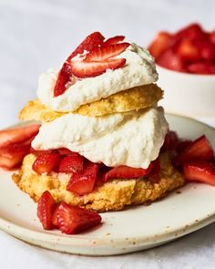 strawberries and whipped cream on top of biscuits