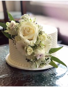 a white wedding cake with flowers on top