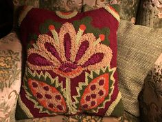 a red and green pillow sitting on top of a couch