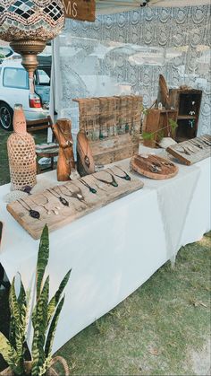 an outdoor market table with various items on it and a vase in the middle next to it