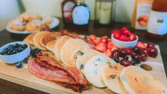 the breakfast is ready to be eaten on the wooden cutting board with berries and blueberries