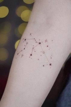 a small star cluster tattoo on the arm